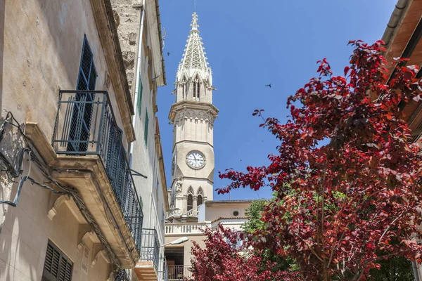 Utsikt över byn, fasad byggnad, blommor och torn kyrka, historiska center Manacor, Mallorca Island, Balearerna. — Stockfoto