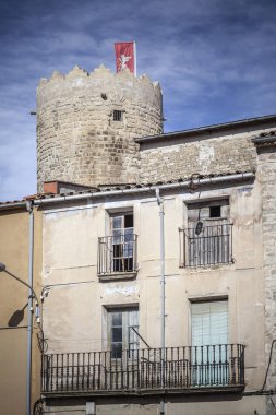 Sea view, cephe evleri ve bayrak Santa Coloma de Queralt, il Tarragona, İspanya ortaçağ köyü ile eski kule.