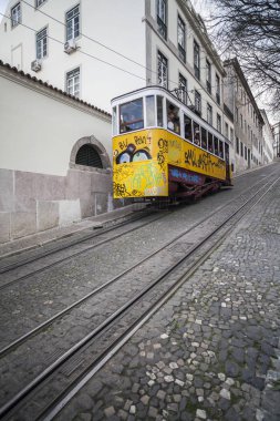 Lizbon tipik sarı tramvay ile dik sokak.