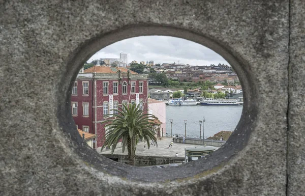 Widok na rzekę Douro i budynków przez otwór w mur w Porto, Portugalia. — Zdjęcie stockowe