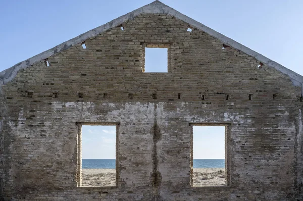 Будівельна структура фасаду з вікнами, пляжем і морем на фоні . — стокове фото