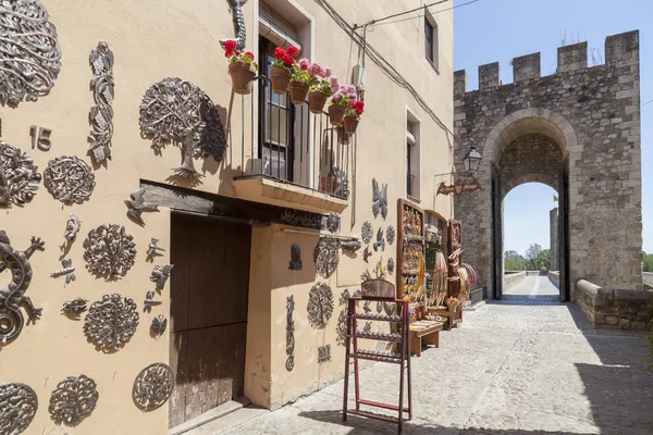 Straßenblick und Turm der romanischen Brücke und Souvenirladen im mittelalterlichen Dorf Besalu, Katalonien, Spanien. — Stockfoto