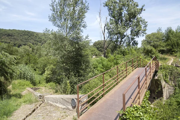Paisaje y puente metálico en la región de Garrotxa, zona volcánica.Castellfollit de la Roca, Cataluña, España . — Foto de Stock