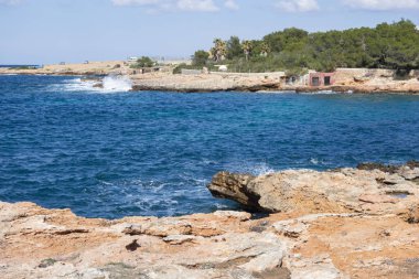 Akdeniz deniz, kıyı görünümü, kaya oluşumu, kasaba Sant Antoni, Ibiza Adası, İspanya.