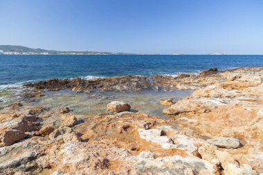 Akdeniz deniz, kıyı görünümü, kaya oluşumu, kasaba Sant Antoni, Ibiza Adası, İspanya.