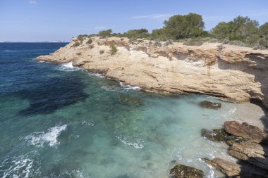 Akdeniz deniz, kıyı görünümü, kaya oluşumu, kasaba Sant Antoni, Ibiza Adası, İspanya.