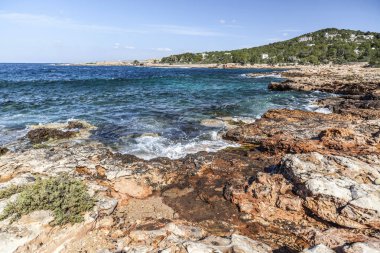 Akdeniz deniz, kıyı görünümü, kaya oluşumu, kasaba Sant Antoni, Ibiza Adası, İspanya.