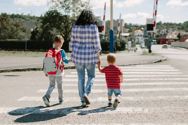 Anne çocuklarını tutan ve okul yolu üzerinde bir yol geçiş
