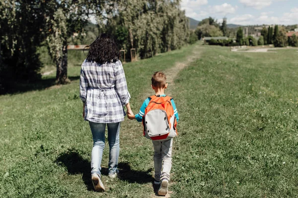 Rückansicht eines Schülers und seiner Mutter, die gemeinsam zur Schule gehen — Stockfoto