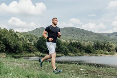 Erkek koşucu ülke boyunca bir su birikintisi genelinde çalışan zevk
