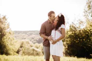 Mutlu hamile çifte sarılma ve öpüşme