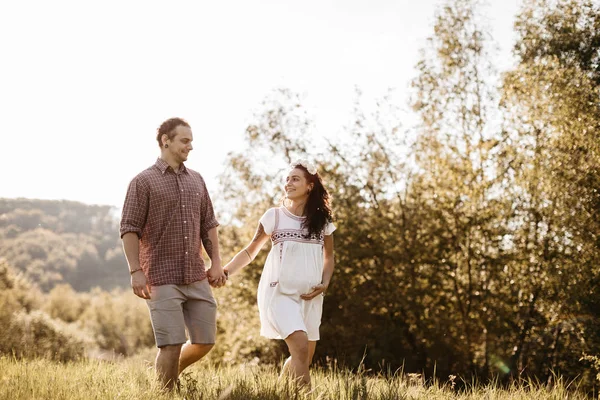 Alegre esperando casal andando na natureza — Fotografia de Stock