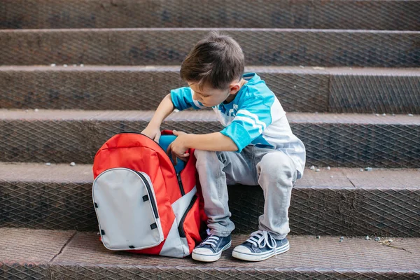 Schüler überprüft den Inhalt seiner neuen Schultasche — Stockfoto