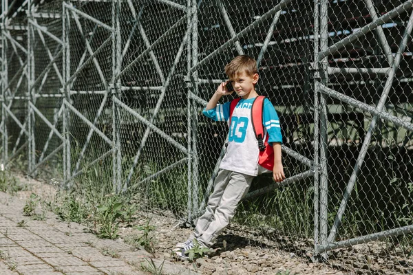 Młody student z telefonu komórkowego w drodze rano do szkoły — Zdjęcie stockowe