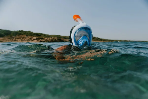 Woman swimming at water surface wearing snorkel mask. — Stockfoto