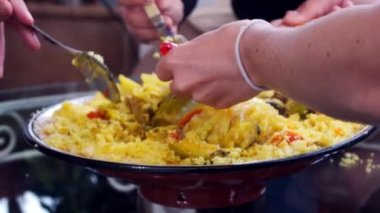 bir grup insan geleneksel Fas yemeği kuskus ile et ve sebze hep birlikte bir tabak yemek. Kaşık ile el. Aile yemeği. Paylaşımı. Yakın çekim. Tangier, Morocco.