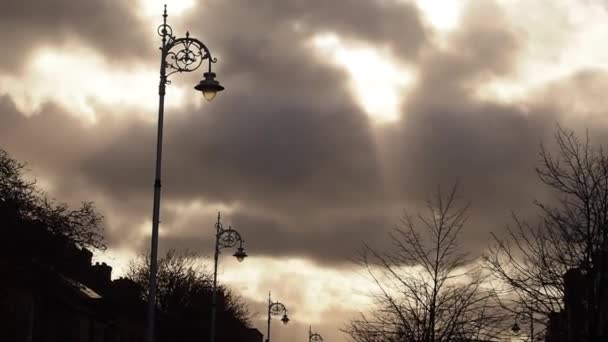 Sun is Shining via grote wolken in de tijd van Twilling. Daken en toppen van bomen zonder bladeren. Mysterie. het licht uit de hemel tussen zonsondergang en volledige nacht. — Stockvideo