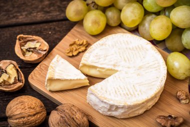 Camembert peyniri ceviz ve ahşap rustik zemin üzerine Yeşil üzüm