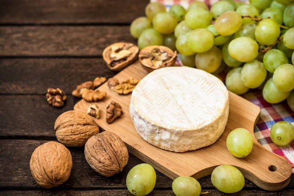 Camembert peyniri ceviz ve ahşap rustik zemin üzerine Yeşil üzüm