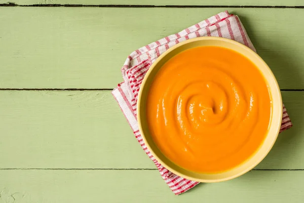 Pumpkin soup on green rustic wooden background — Stock Photo, Image