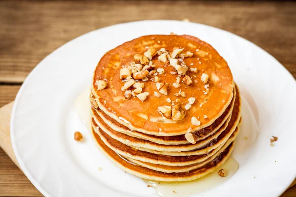 Panqueques con miel y nueces sobre fondo rústico de madera — Foto de Stock