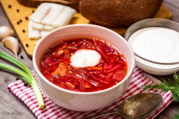 Barszcz - Tradycyjna zupa ukraińskich i rosyjskich z Buraki czerwone ceramiczne miski na podłoże drewniane — Zdjęcie stockowe
