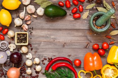 Çerçeve farklı taze organik sebze ve baharat ahşap masa üzerinde. Sağlıklı doğal gıda arka plan kopya alanı ile.