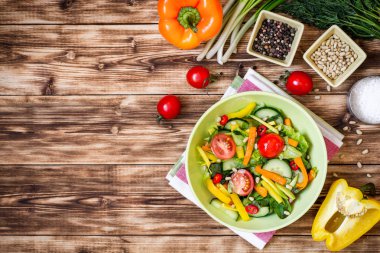 Taze salata sebze, yeşillik ve çam fıstığı ahşap arka plan üzerinde