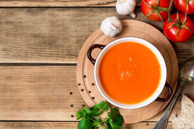 Ahşap arka plan üzerinde seramik kase domates çorbası.