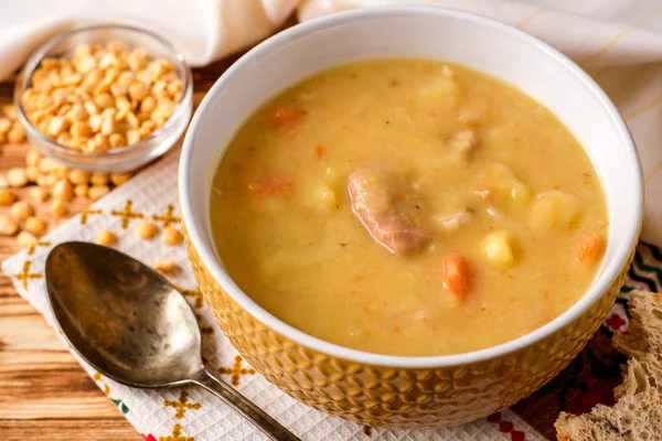 Sopa de ervilha dividida com carne, batatas e cenouras em tigela de cerâmica em fundo de madeira . — Fotografia de Stock