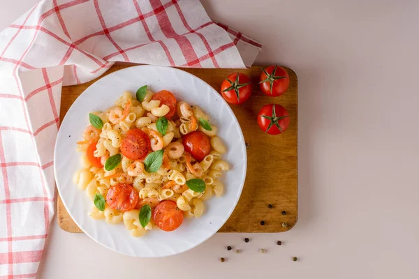 Pasta con gambas, tomates cherry y albahaca en plato blanco . — Foto de Stock