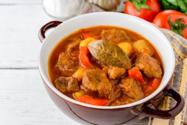 Gulaş Beyaz ahşap zemin üzerinde seramik kase. Geleneksel Macar çorbası.