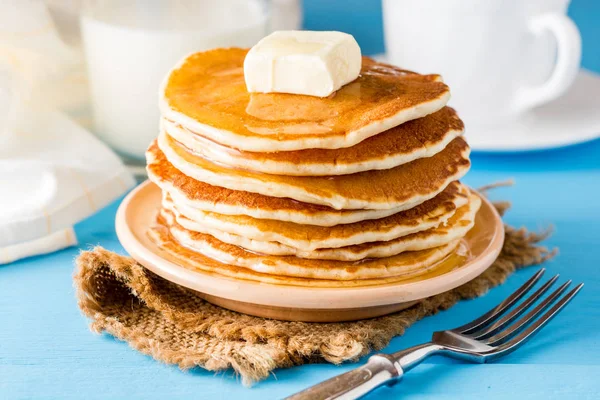 Pancakes with butter and honey on blue wooden table. — Stock Photo, Image