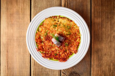 Patates rosti ile dereotu ve ahşap masa tabağa tuzlanmış ringa.