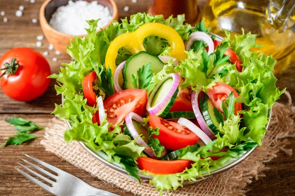 Fresh vegetable salad with greens on wooden table. — Stock Photo, Image