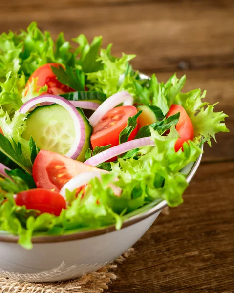 Ahşap masa üzerinde yeşillikleri ile taze sebze salatası.