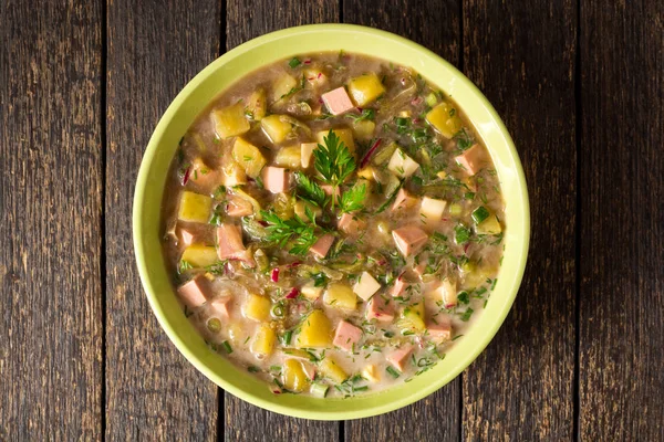 Okroshka. Sosis, sebze ve Kvas kase ahşap arka plan üzerinde geleneksel Rus yaz soğuk çorba.