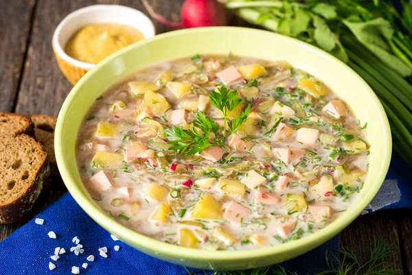 Okroshka. Sosis, sebze ve Kvas kase ahşap arka plan üzerinde geleneksel Rus yaz soğuk çorba.