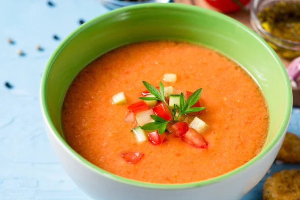 Sommaren kall soppa gazpacho med persilja och grönsaker på blå betong bakgrund. — Stockfoto