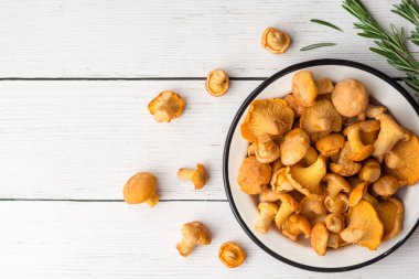 Beyaz ahşap zemin üzerinde plaka ham mantar Cantharellus cibarius.