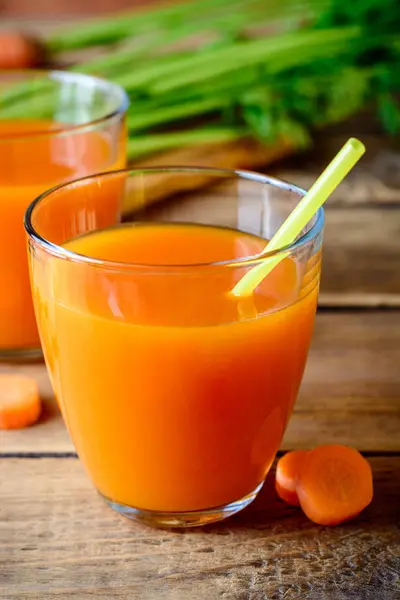 Свежий морковный сок в стаканах на деревенском деревянном столе . — стоковое фото