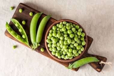 Gri taş zemin üzerine seramik kase taze yeşil bezelye