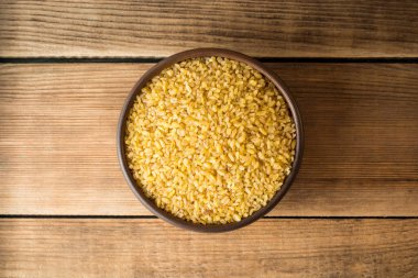 Rustik ahşap zemin üzerine seramik kase kuru bulgur buğday