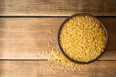 Rustik ahşap zemin üzerine seramik kase kuru bulgur buğday