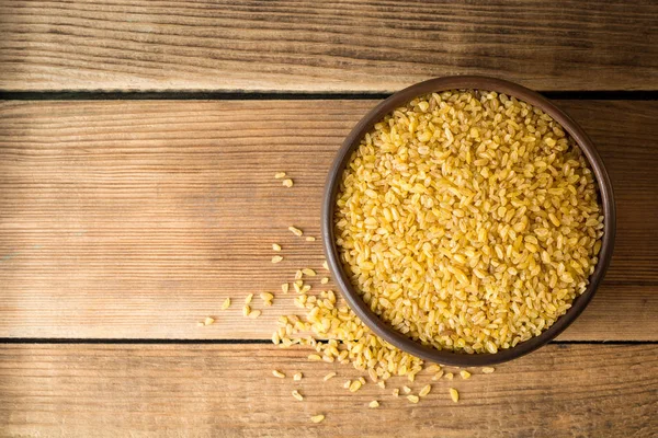 Rustik ahşap zemin üzerine seramik kase kuru bulgur buğday