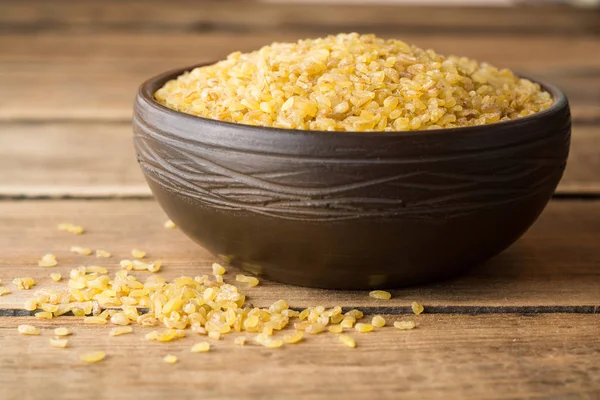 Rustik ahşap zemin üzerine seramik kase kuru bulgur buğday