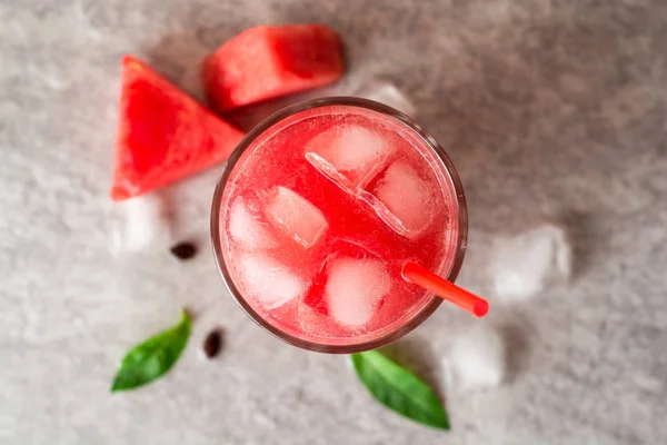 Batido de sandía fresca con hielo y menta en vidrio sobre fondo de piedra gris — Foto de Stock