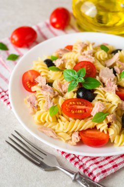 Düdük makarna salatası ton balığı, domates, Siyah Zeytin ve fesleğen gri taş zemin üzerine