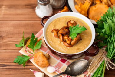 Mantar kremalı çorba chanterelles ve ahşap zemin üzerine maydanoz ile