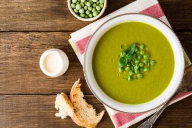 Yeşil bezelye çorbası kase ahşap tablo